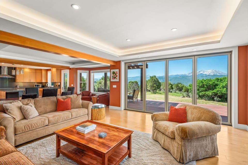 open floor plan living room, dining, kitchen with bi fold glass doors to patio