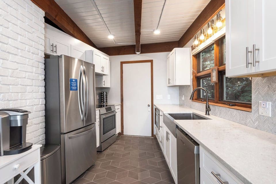 Kitchen with stainless appliances, dishwasher, Keurig and drip-style coffee pot, and access to the garage.