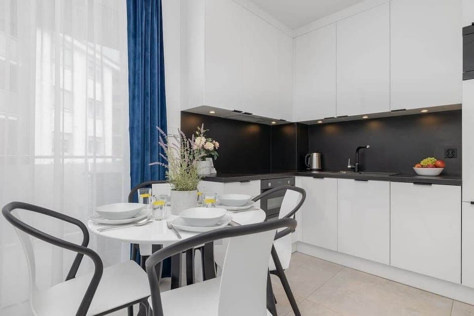 Dining Area – Open-plan dining space with a round table and four chairs, connected to the kitchen.

