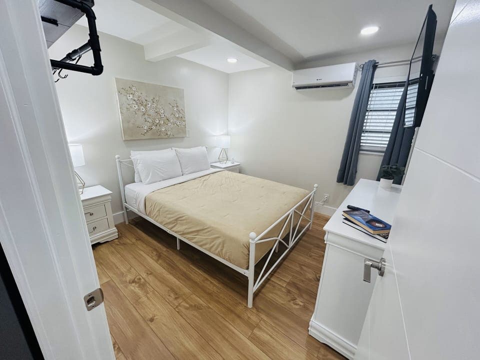 Relax in Bedroom 1 with a queen-size bed, artistic flair from captivating paintings, and functional side tables. Discover a cozy haven designed for restful nights and stylish living. 