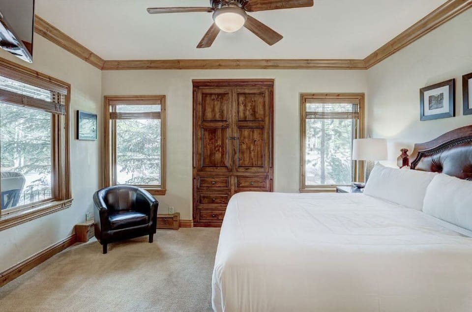Sleep soundly in the elegant bedroom, featuring a king-sized bed, tasteful decor, and a ceiling fan for added comfort.
