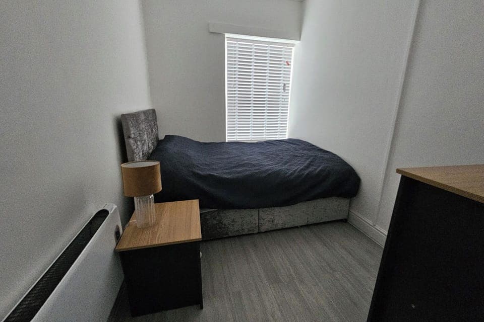 This comfortable room offers a comfortable bed with soft linens and warm lighting, creating a peaceful atmosphere. 