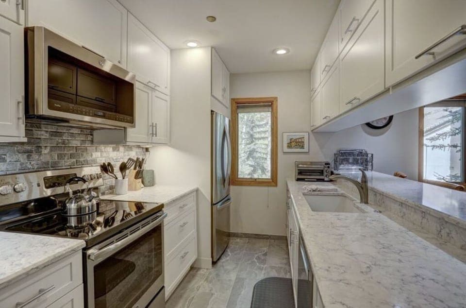 Prepare meals in the modern kitchen, equipped with high-end appliances, granite countertops, and plenty of storage space.