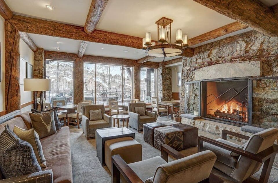 Gather in our grand living room, featuring a stunning stone fireplace, vaulted ceilings, and plush seating. Perfect for cozy evenings with loved ones.