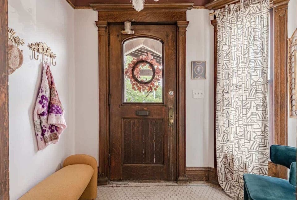 Step into serenity! This cozy entryway featuring a charming wooden door and a welcoming bench invites you to pause and unwind.  #HomeVibes