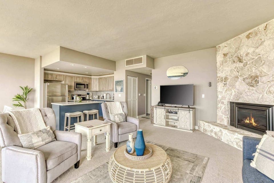 Cozy up by the fireplace! Our inviting living area, blending seamlessly with the kitchen, is perfect for relaxation.