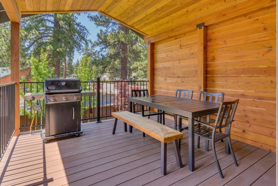 - Covered patio with outdoor dining table and bench seating  
- Gas BBQ grill for family cookouts and gatherings  
- Scenic pine tree views perfect for mountain stays