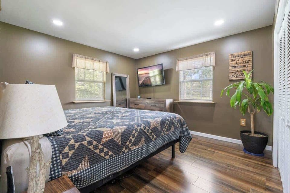 The main bedroom features a spacious and comfortable king-size adjustable bed, lamps, a big-screen Smart TV, ample storage, and a roomy closet, providing everything you need for a restful and organized stay.