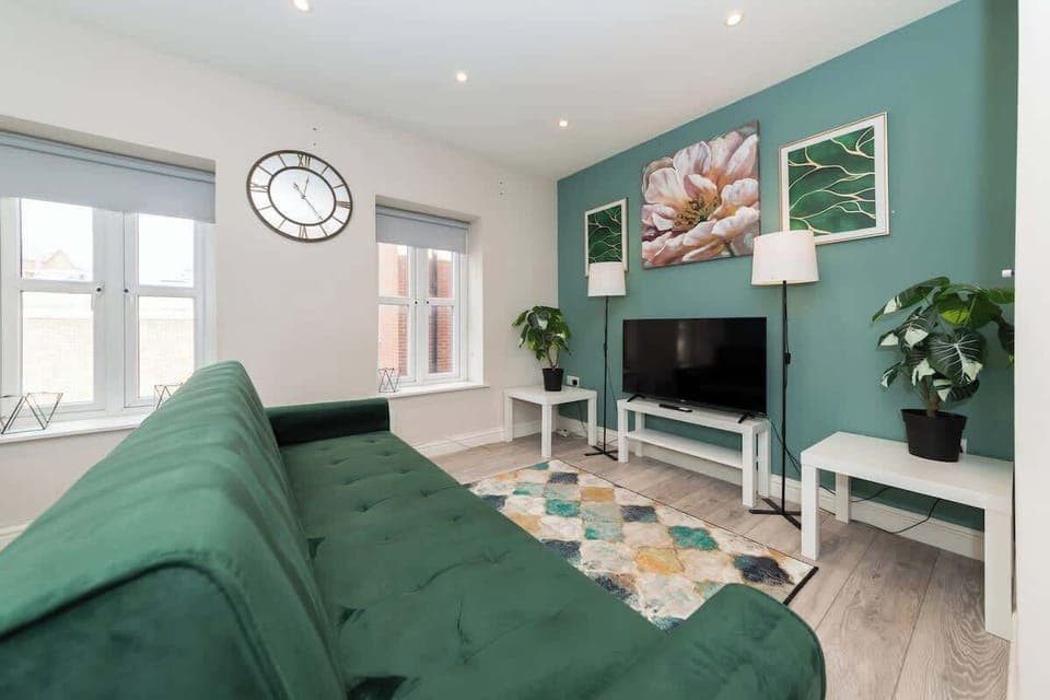 Bright and stylish living room area featuring modern decor a comfy area sofa, smart tv, and natural light perfect for relaxing after a day of exploring or working