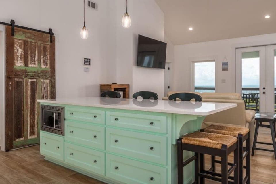 Gather around this charming mint-green kitchen island where you'll create memories over morning coffee and evening conversations in your stylish retreat.