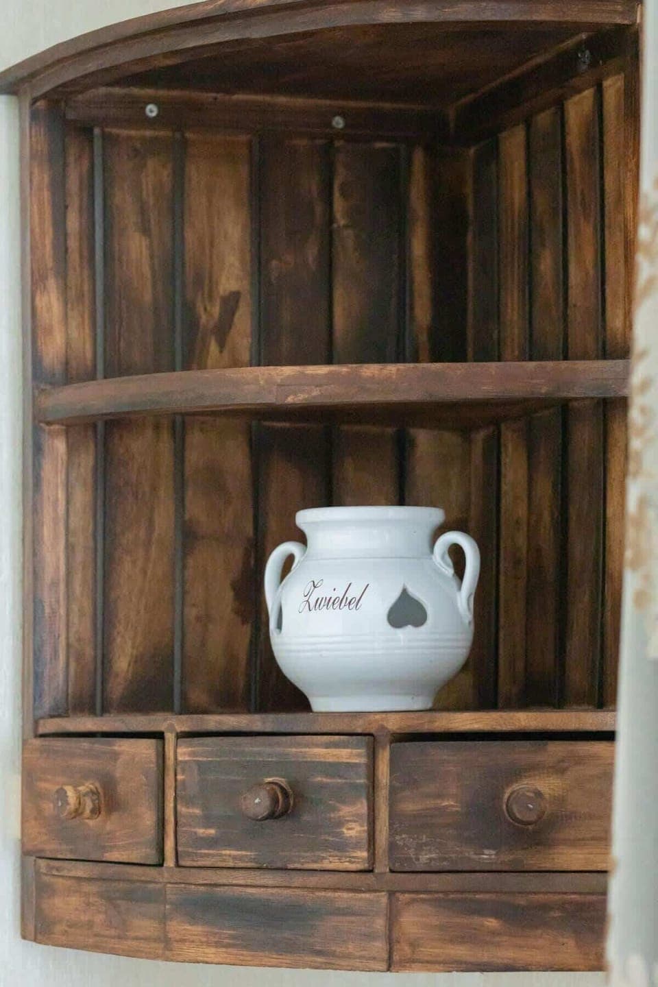 A rustic wooden shelf, showcasing unique decorative pieces, combining practicality with a warm, inviting design.
