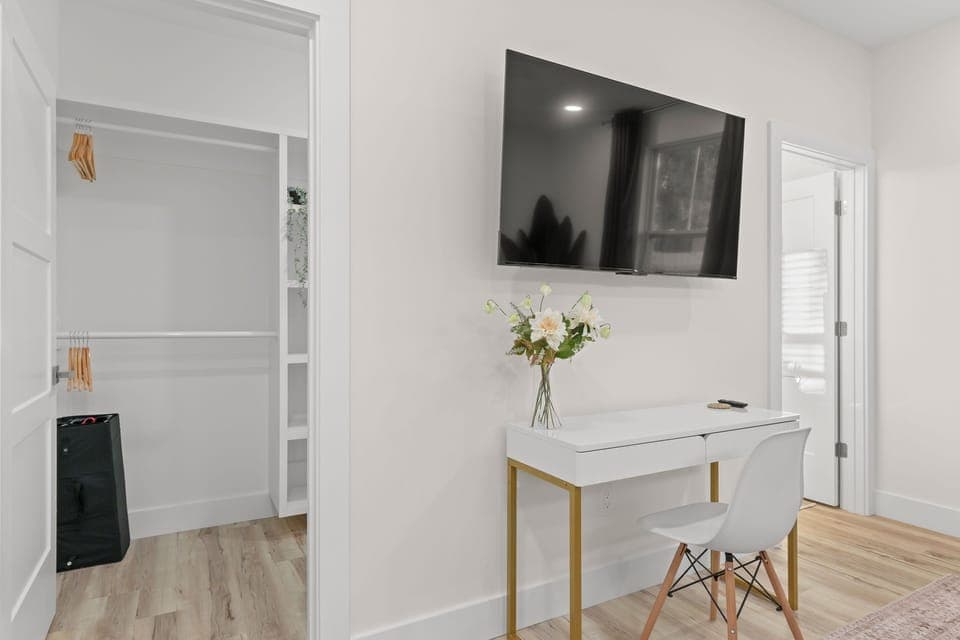 Modern room with a sleek desk, TV, and stylish décor for relaxation or work! 
