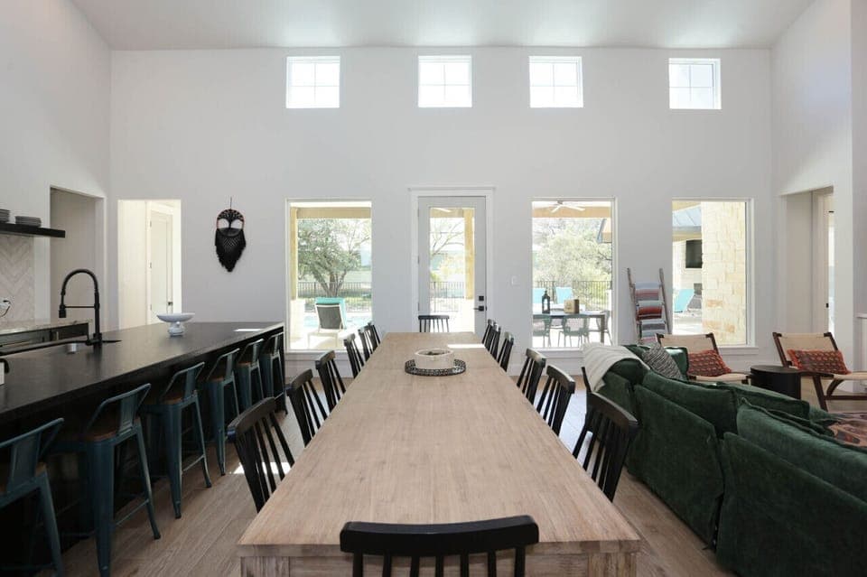 Gather around the spacious dining table, perfect for family meals or group gatherings, with natural light streaming through large windows for a warm, inviting atmosphere.