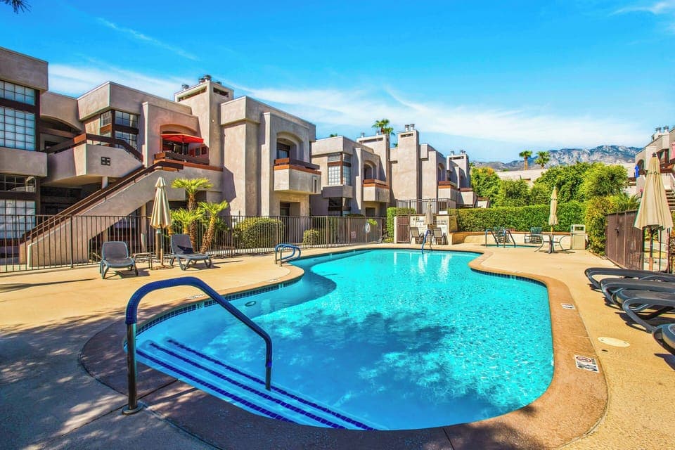 Resort-style swimming pool with loungers and mountain views