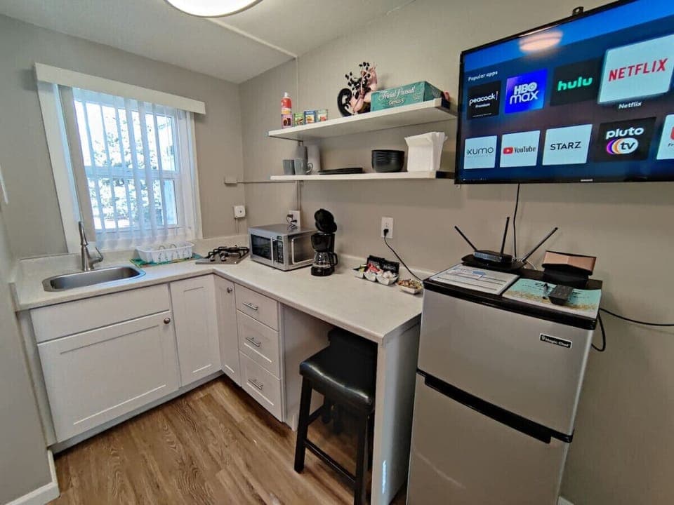 Discover the charm of this well-equipped kitchen area! With a sleek microwave, spacious refrigerator, and versatile microwave oven, you have everything you need to whip up your favorite dishes. 🥘💖