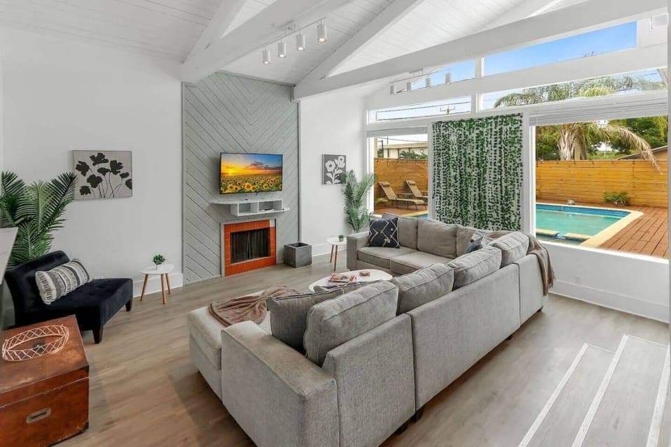 Enjoy a seamless indoor-outdoor experience in this bright living room, featuring stunning views of the pool for a relaxing and inviting atmosphere.