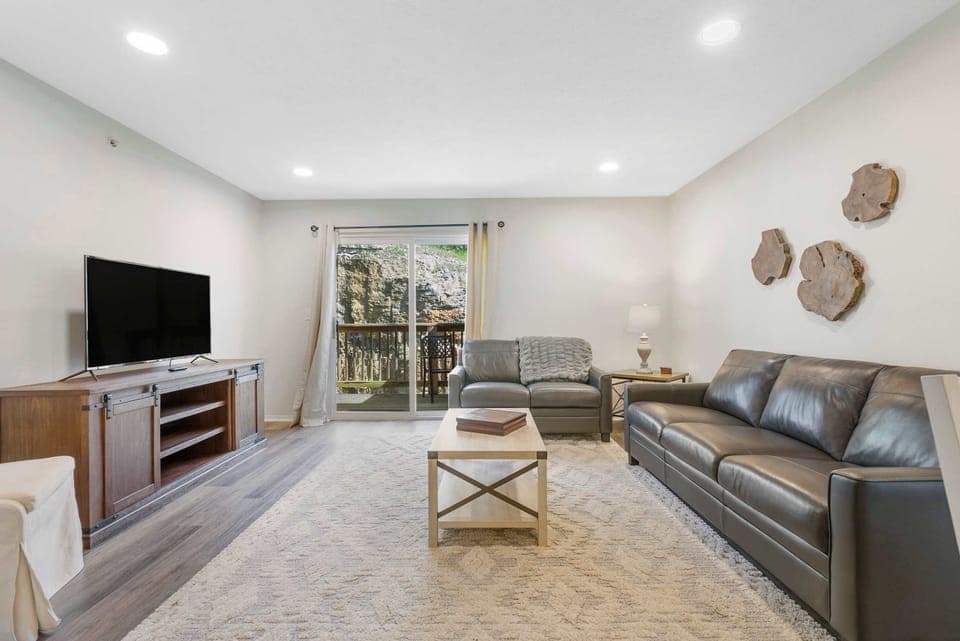 Open living space with ample seating, Smart TV, and balcony access