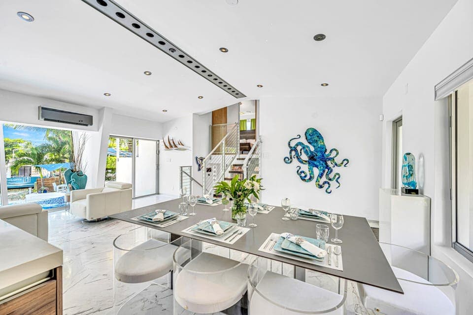 The dining room comfortably seats eight and offers a complete waterfront view of the pool and canal.