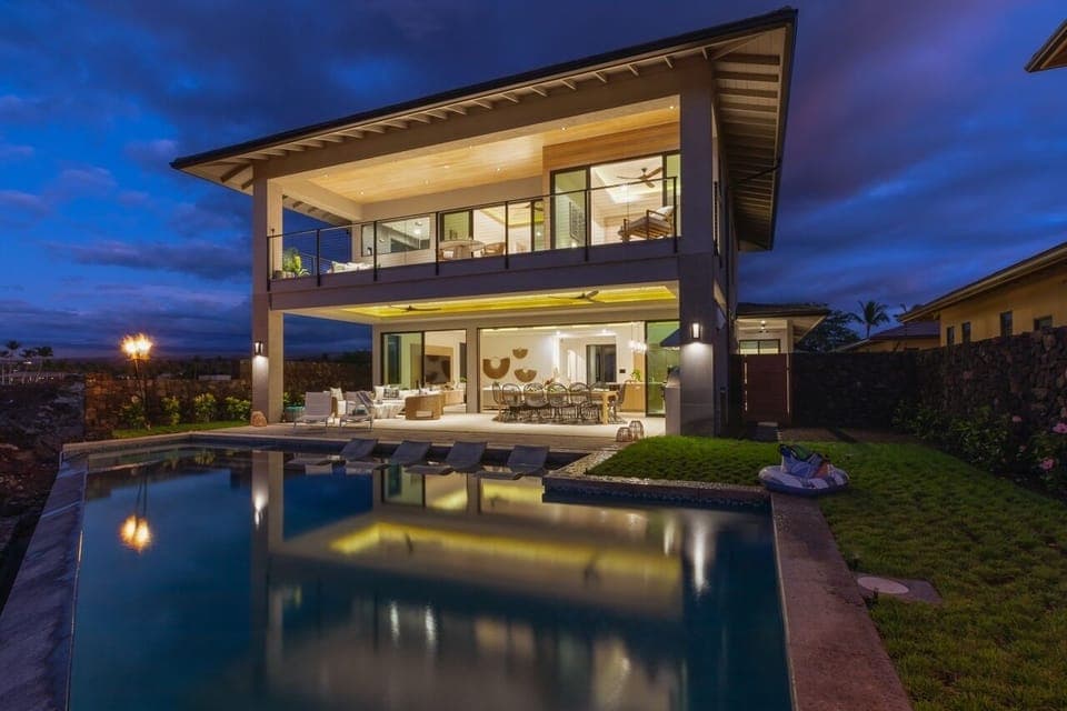 As evening falls, this home transforms into a peaceful retreat with glowing interiors and a tranquil poolside setting.