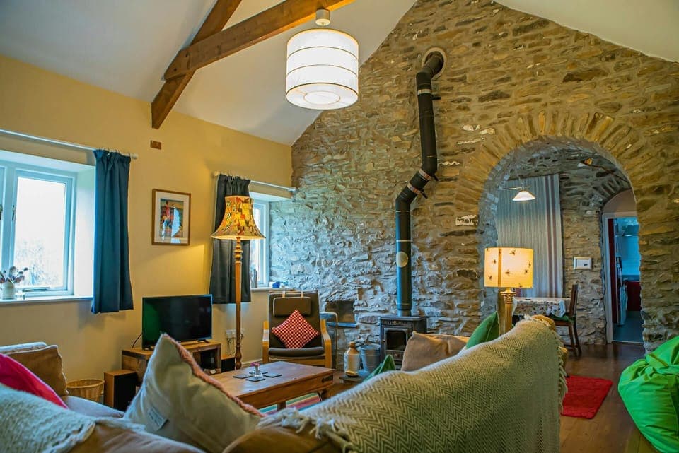 Sitting room with large corner sofa, TV and log burner