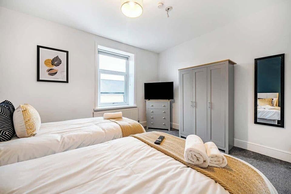 Whether you're sharing the room or just enjoying some extra space, this bedroom with two single beds and a TV has everything you need for a restful stay. 🛏️📺