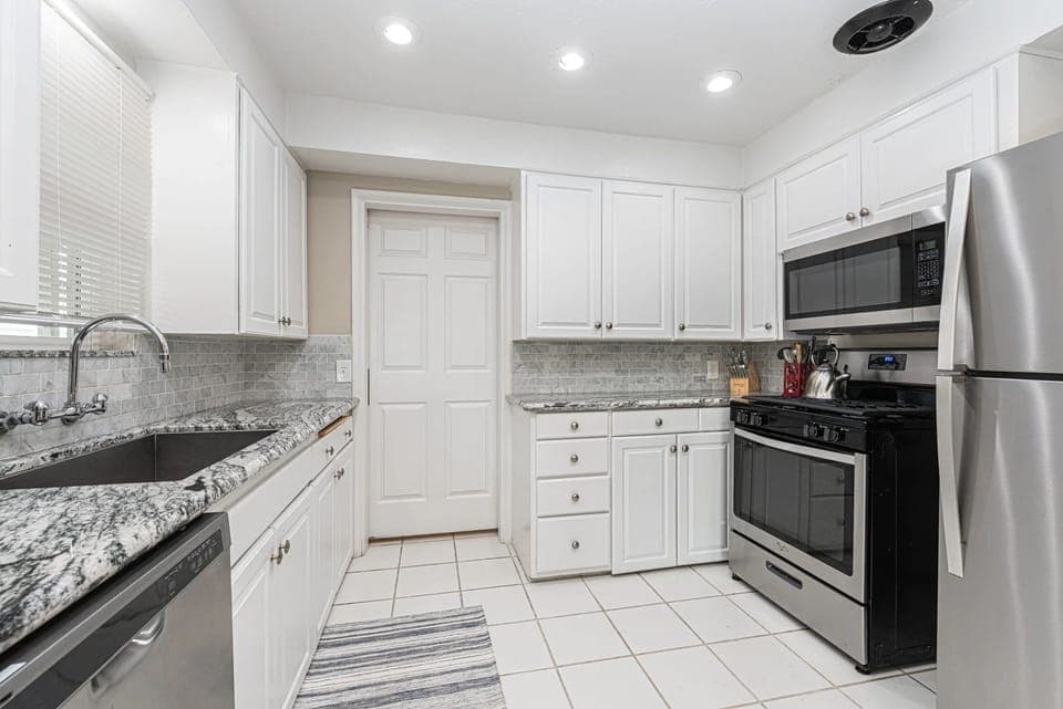 Updated kitchen with granite countertops, stainless steel appliances, and crisp white cabinetry for effortless cooking
                