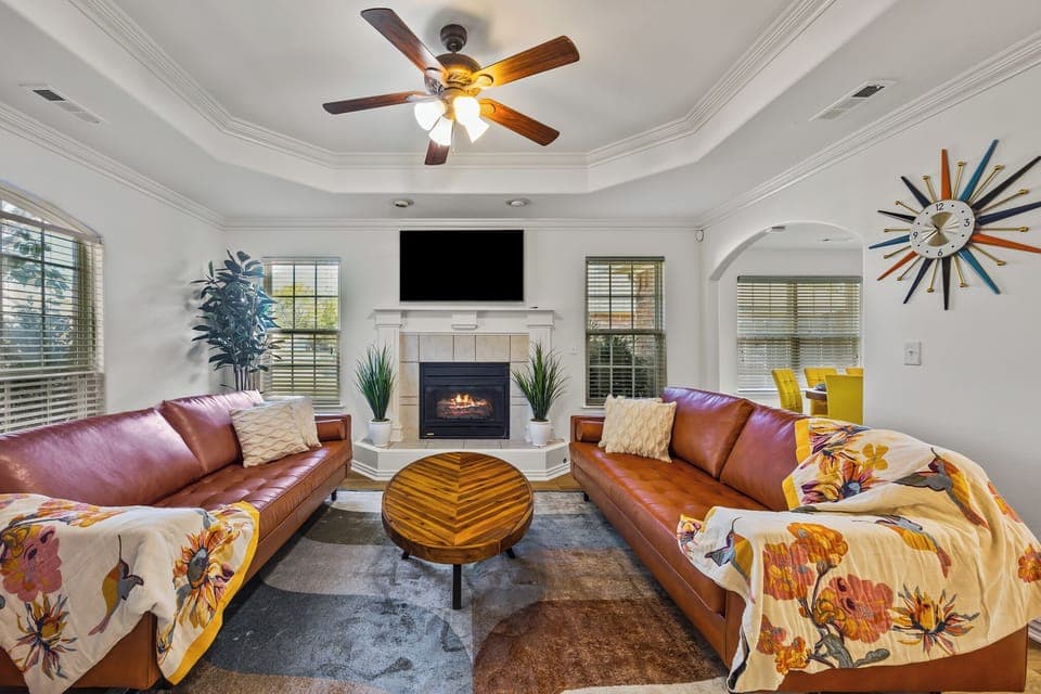 Large living room full of sunshine. Genuine leather couches & solid wood table.