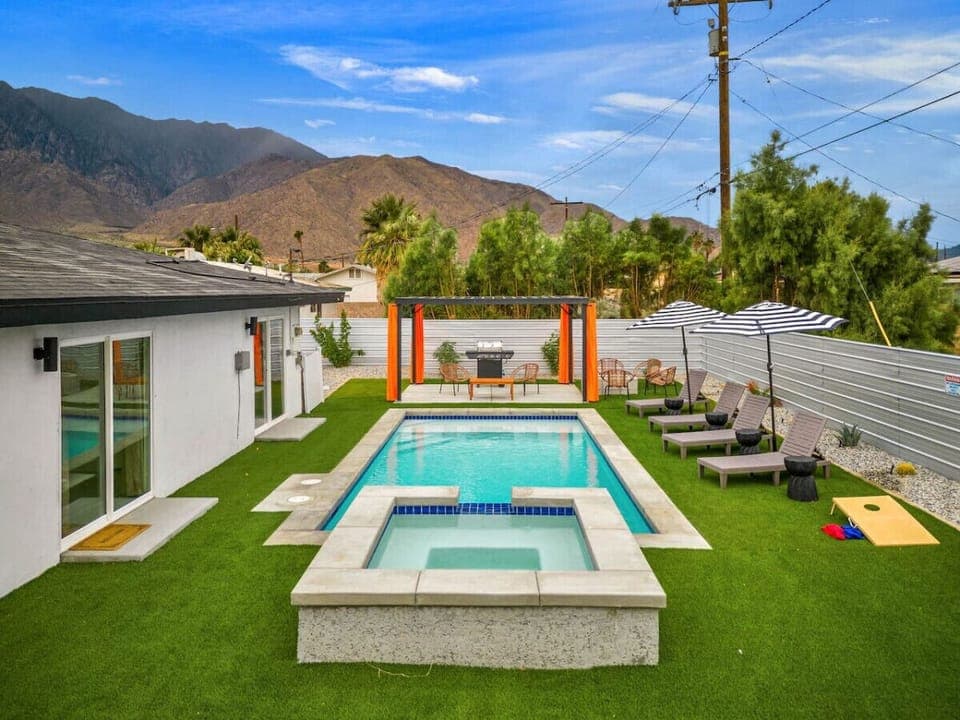 Sunlit backyard w/ a sparkling pool, loungers & mountain views—perfect for cooling off or soaking up the desert vibes.