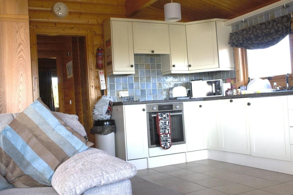 Open plan sitting/kitchen area with door leading to bedrooms; oven, toaster and microwave