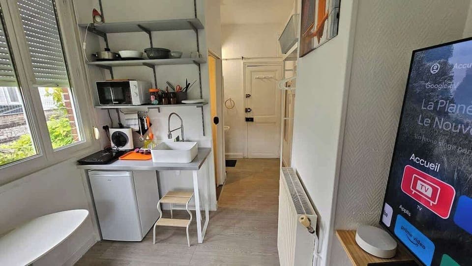 Kitchenette ouverte sur l'espace chambre, équipée avec plaque de cuisson, machine à café, micro-ondes et petit réfrigérateur.