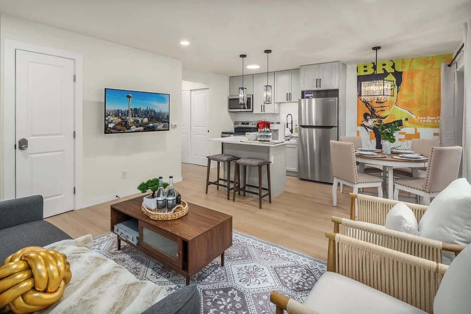 A cozy, well-lit living room with a large TV, comfortable sofa, and chic decor that adds a modern touch to the space.