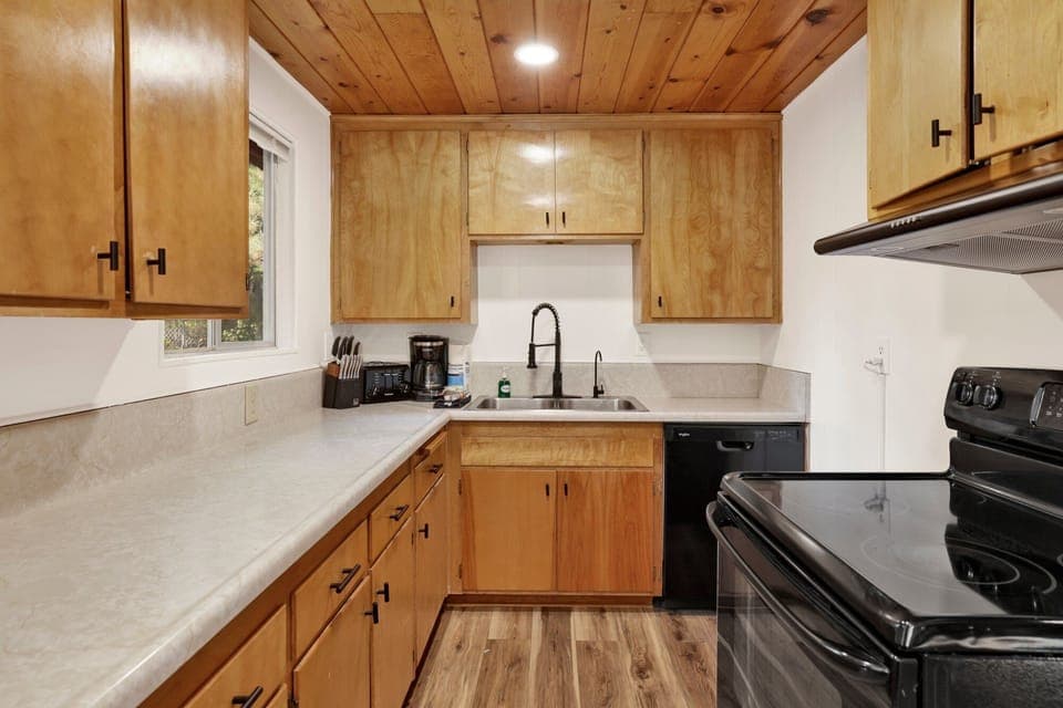 Fully equipped cabin kitchen with ample cabinetry, stove, fridge, and a coffee maker—perfect for cooking meals, morning coffee, and feeling right at home on your stay.