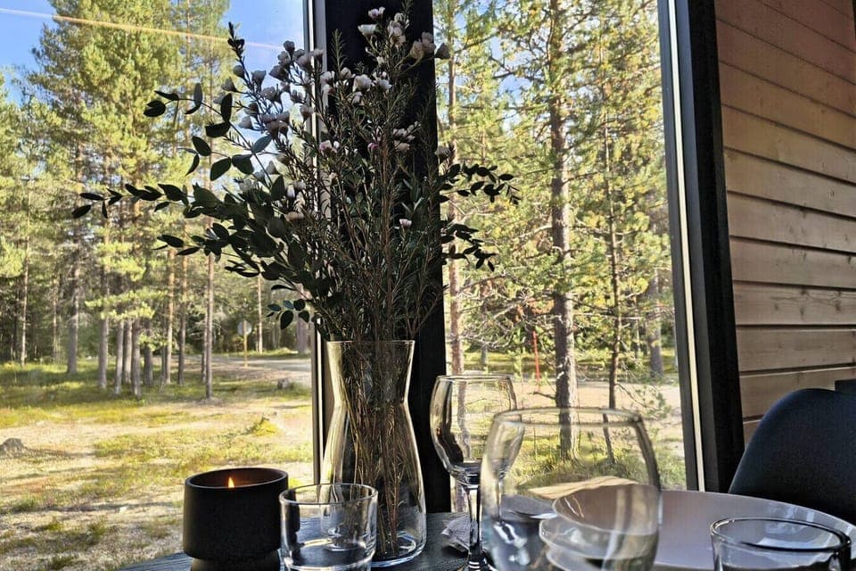 A peaceful forest view with a cozy table setting by the window.