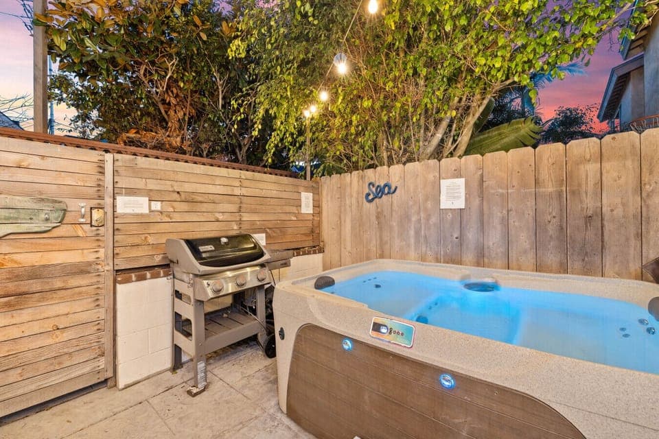 Unwind in the hot tub after a delicious meal from the barbecue grill in this private and lush backyard retreat.