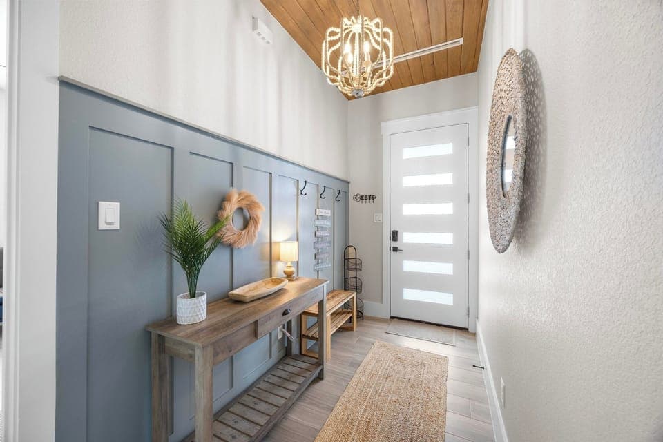 Upstairs foyer to the indoor living area, featuring a coat closet and shoe rack