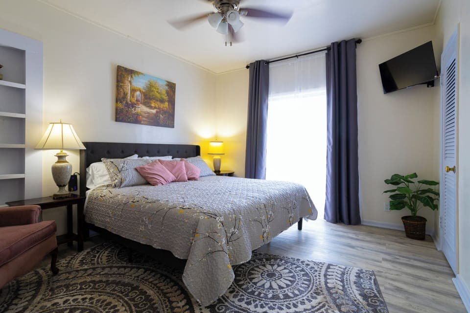 Bathed in natural light, the bedroom retreat, features a plush king bed & smart TV