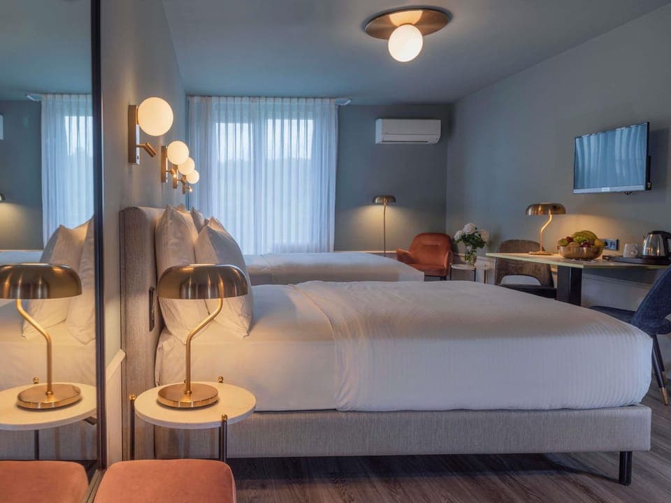 Hypo-allergenic bedding, desk, laptop workspace, blackout drapes