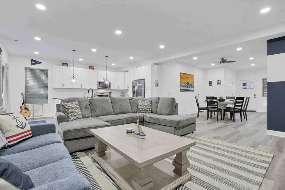 Cozy open-concept living room with a queen-sized pull-out sofa, seamlessly connected to the dining area and fully equipped kitchen, creating a comfortable space for relaxing, dining, and gathering with family and friends.