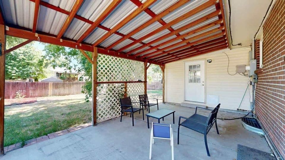 The patio features comfortable furniture, creating a perfect space to relax, dine, or enjoy the fresh air in a cozy outdoor setting.