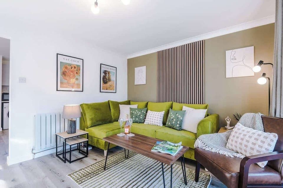 The living room features a comfortable sofa bed, a smart TV, and an open-plan dining area, perfect for relaxing and entertaining. Large doors offer easy access to the backyard, creating a seamless connection between indoor and outdoor living spaces.