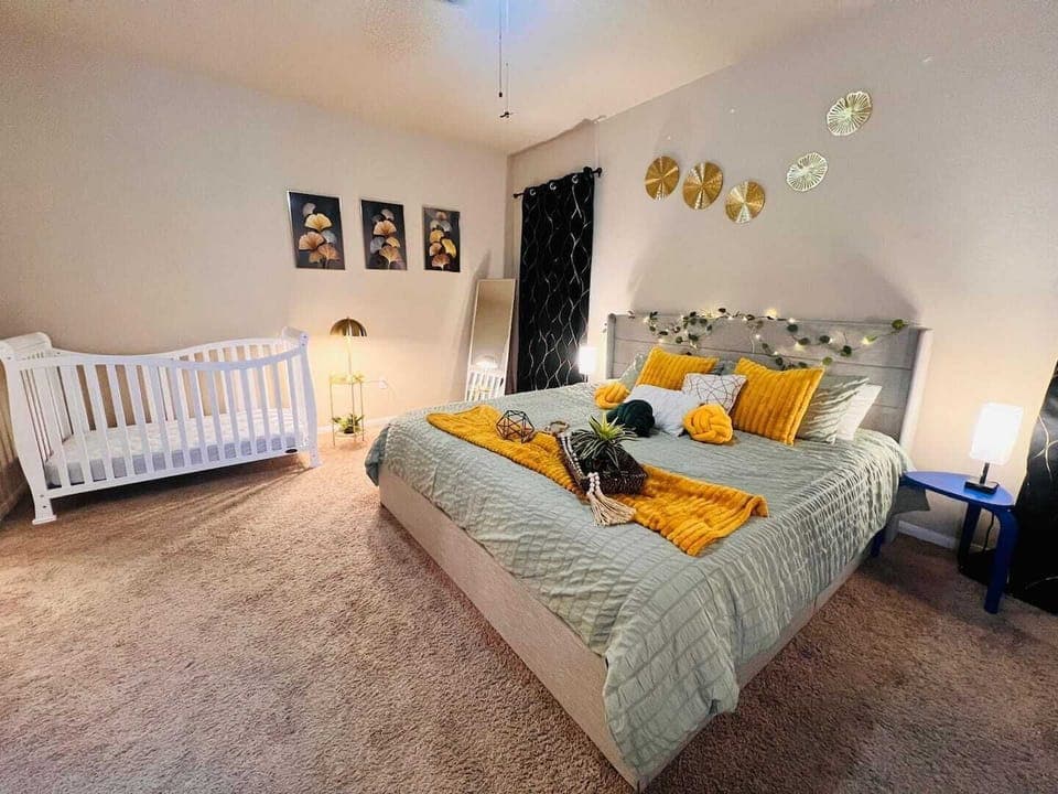 Peaceful master bedroom with king bed, warm tones, plush bedding, and a crib for young travelers. Close to Seton Medical Center and Plum Creek Trail for added convenience and relaxation.

