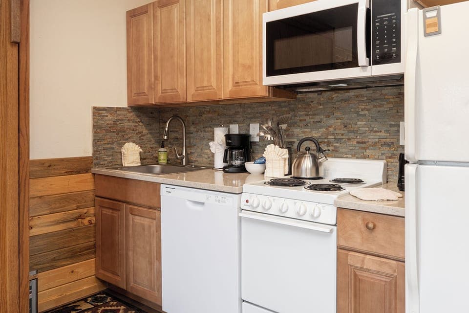Your fully equipped kitchenette at 564 SilverCreek Inn with granite counters, stone backsplash, and all appliances makes meal prep a pleasure during your stay.
