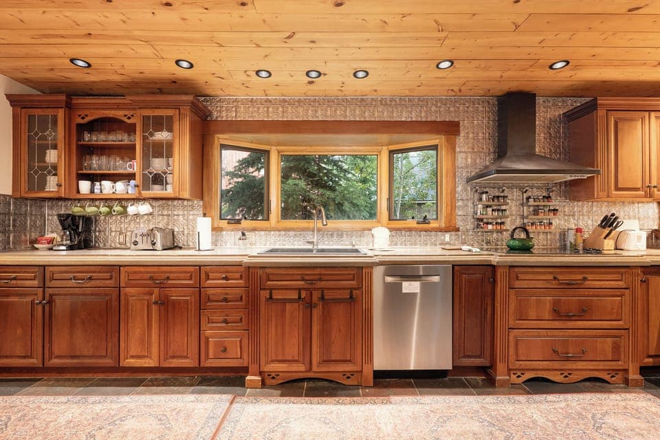 Your gourmet kitchen features rich wood cabinets, stone countertops, and a garden view window—perfect for preparing memorable meals during your stay.