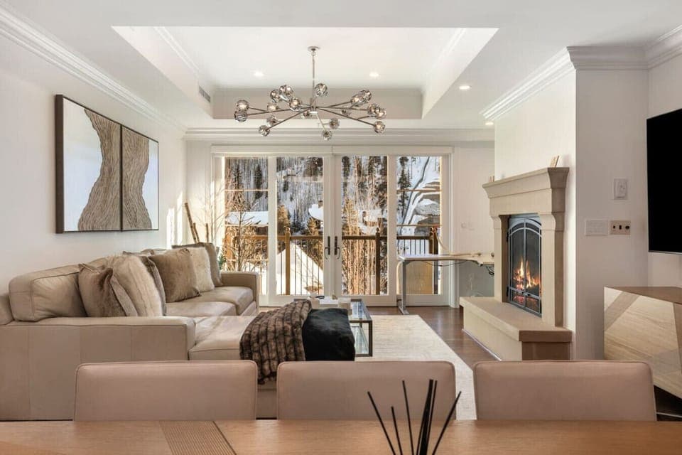 Spacious living area with floor to ceiling windows, comfortable seating, smart TV and gas fireplace