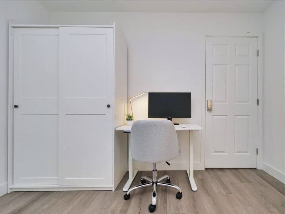 Clean and organized workspace with a desk, chair, and a spacious wardrobe for keeping things tidy.