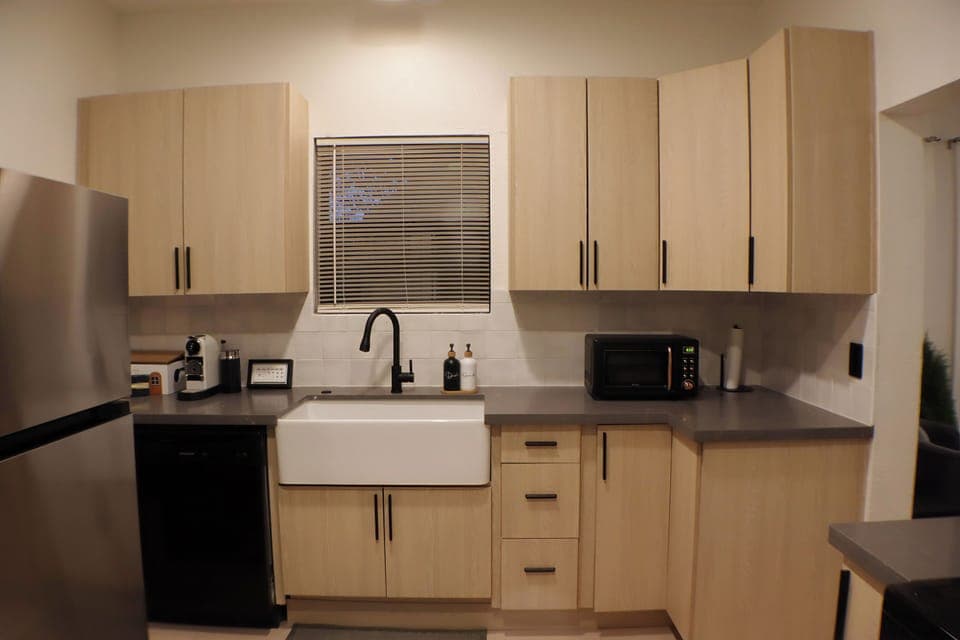 Modern kitchen featuring a farmhouse sink, updated appliances, and generous counter space.