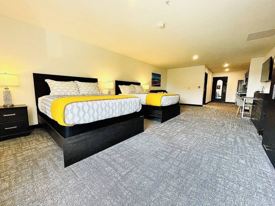 Cozy bedroom featuring a comfortable beds and a sofa with vibrant throw pillows, ideal for relaxing after a day of exploring.