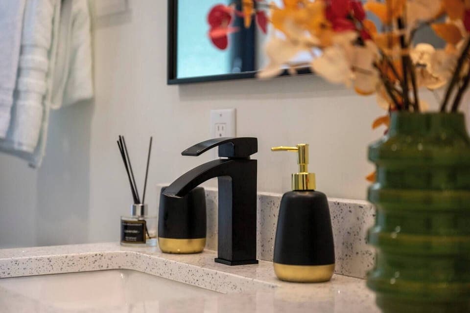 A touch of elegance! This vanity setup features modern black and gold accents, adding a sophisticated flair to your stay.