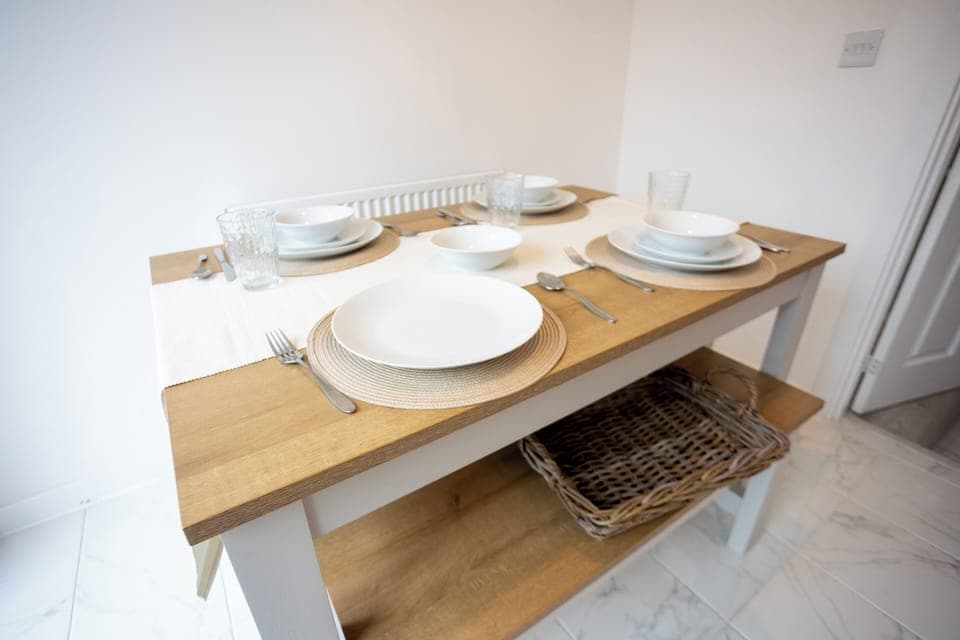 Dining table with bench seating. Plates, bowls, cutlery and cups available. 