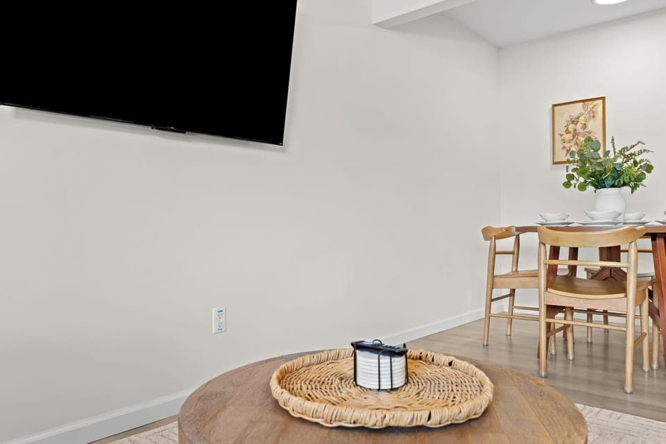 Enjoy a bright and airy space with elegant wall paneling, a mounted Smart TV, and modern furnishings.